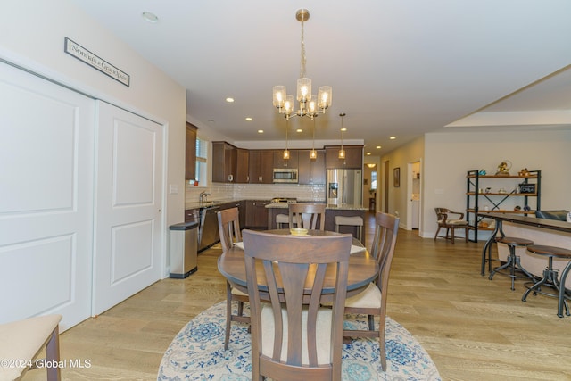 dining room featuring recessed lighting, light wood finished floors, and a chandelier