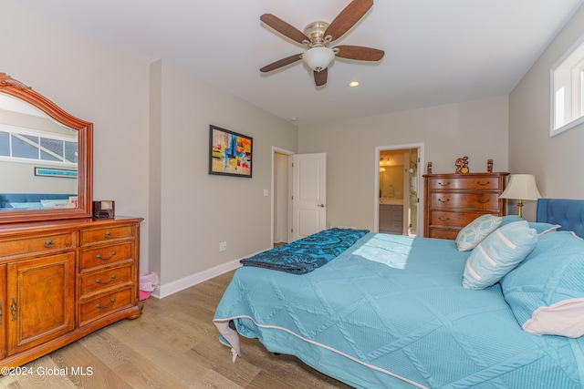 bedroom with a ceiling fan, ensuite bath, recessed lighting, light wood-style floors, and baseboards