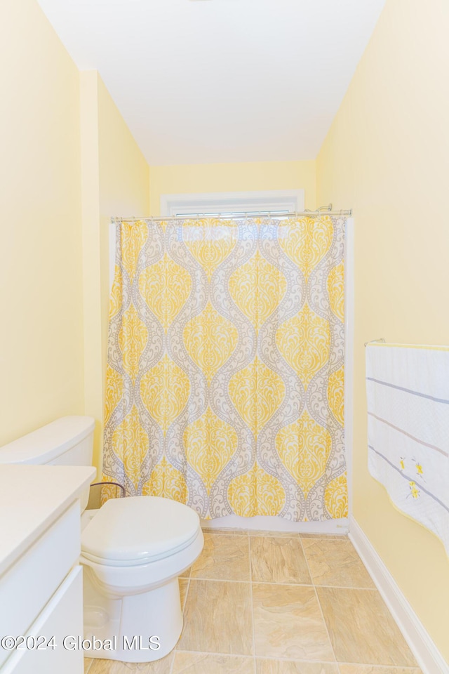 bathroom featuring curtained shower, toilet, and vanity