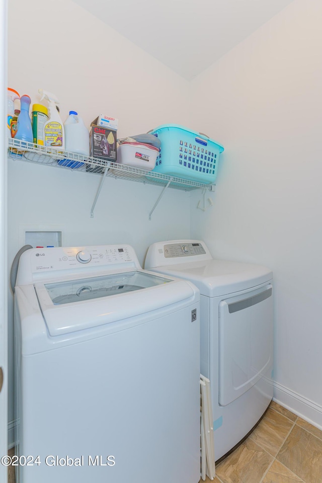 washroom featuring washer and dryer, laundry area, and baseboards