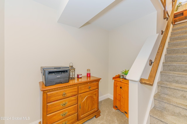 stairs featuring baseboards and carpet