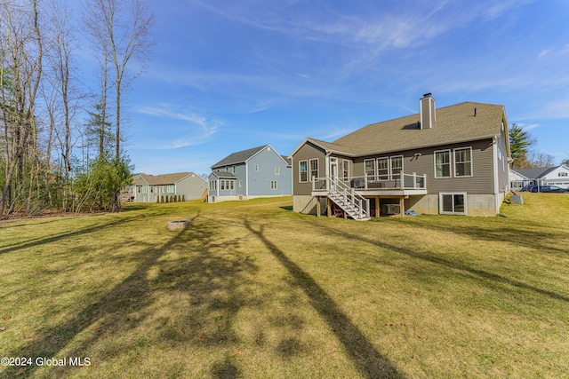 back of property with a residential view, stairs, a lawn, a chimney, and a deck