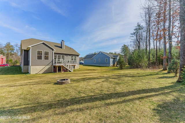 rear view of property with stairs, a fire pit, a lawn, and a chimney