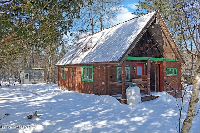 view of snow covered exterior featuring an outbuilding