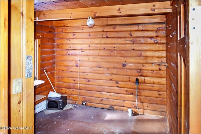 spare room featuring rustic walls and wood ceiling