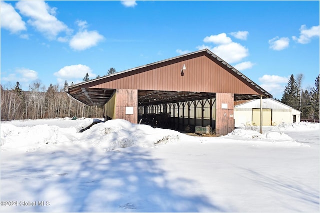 snow covered property with an outbuilding