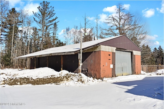 snow covered structure featuring a garage