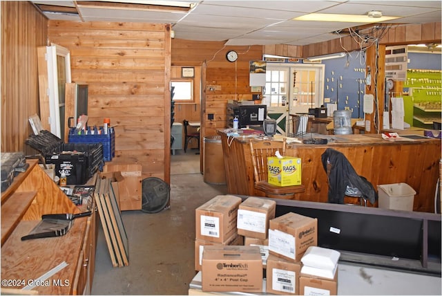 office area featuring wooden walls and concrete floors