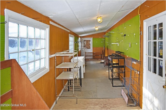 hallway featuring lofted ceiling and concrete flooring