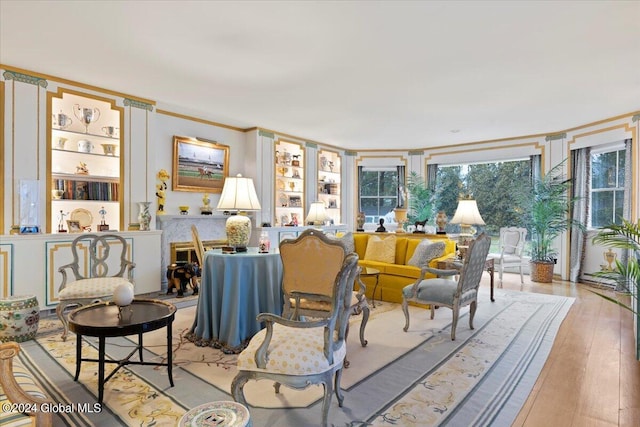 living room with built in features and light hardwood / wood-style floors