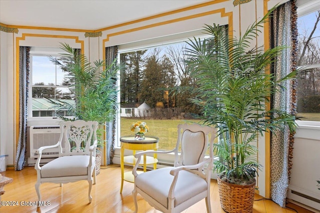 sunroom featuring a baseboard heating unit and a wealth of natural light