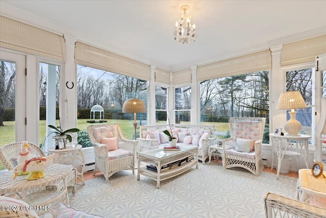 sunroom with a baseboard radiator and a notable chandelier