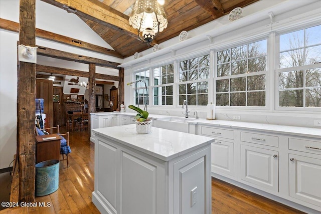 kitchen featuring an inviting chandelier, a kitchen island, light hardwood / wood-style floors, wood ceiling, and white cabinetry