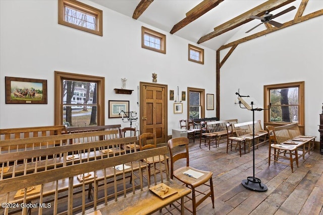 interior space with ceiling fan, dark wood-type flooring, a towering ceiling, and beamed ceiling