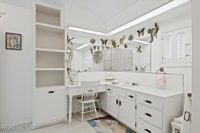 bathroom with lofted ceiling, tile floors, and vanity