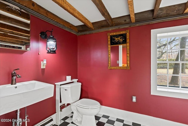 bathroom with toilet, beamed ceiling, tile floors, and sink