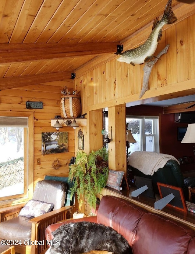 living room with lofted ceiling with beams, wood ceiling, and wood walls