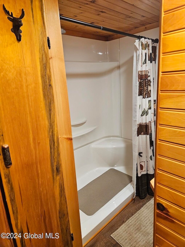 bathroom with curtained shower and wooden ceiling