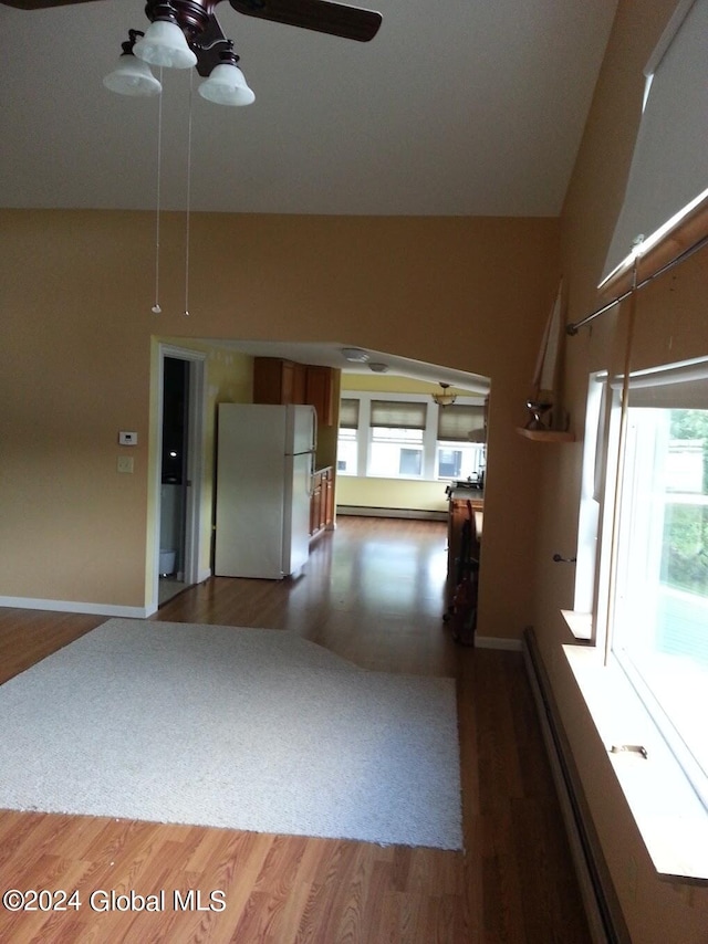 empty room with dark hardwood / wood-style flooring, a baseboard heating unit, and ceiling fan with notable chandelier