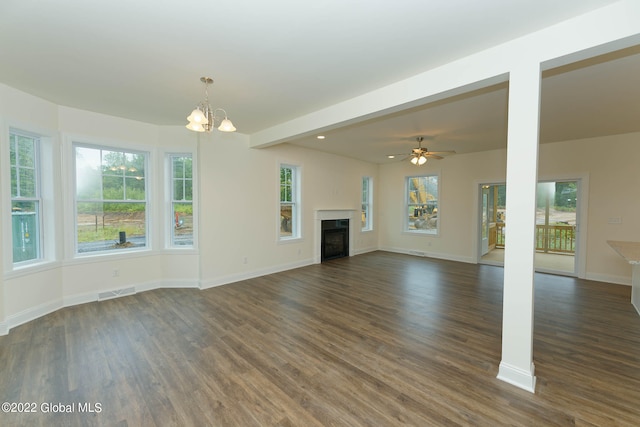 unfurnished living room with ceiling fan with notable chandelier and dark wood-type flooring