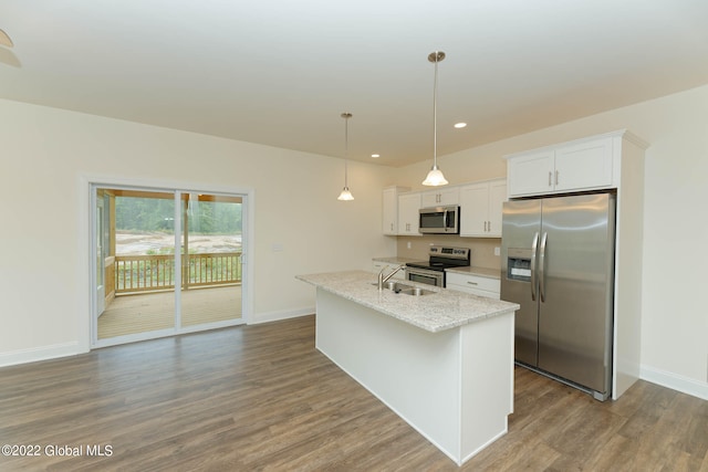 kitchen featuring stainless steel appliances, wood-type flooring, white cabinets, sink, and pendant lighting