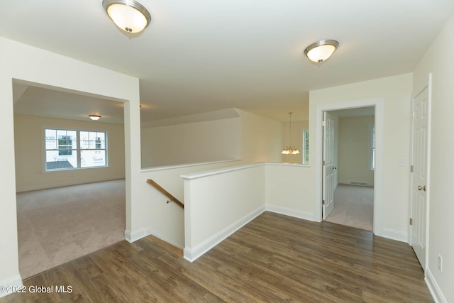 corridor featuring a chandelier and dark hardwood / wood-style flooring