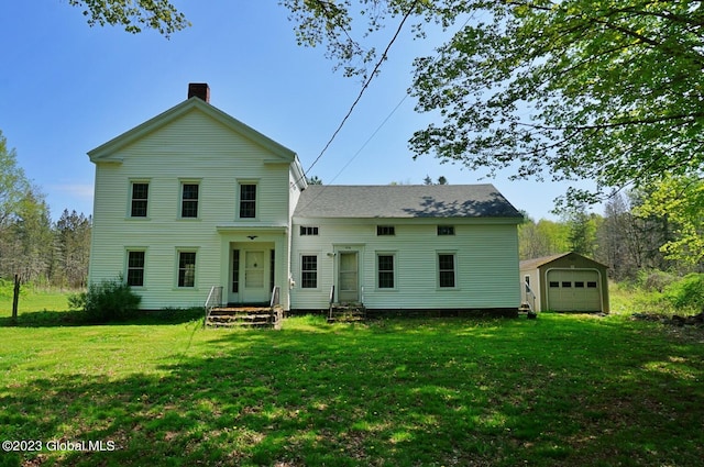 view of front of home with a front lawn, an outdoor structure, and a garage