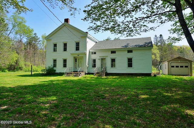 back of house with an outdoor structure, a garage, and a lawn