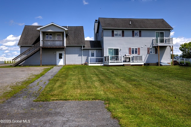 rear view of house featuring a yard and a deck