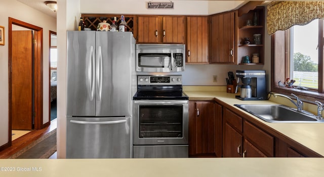 kitchen with dark hardwood / wood-style flooring, stainless steel appliances, and sink