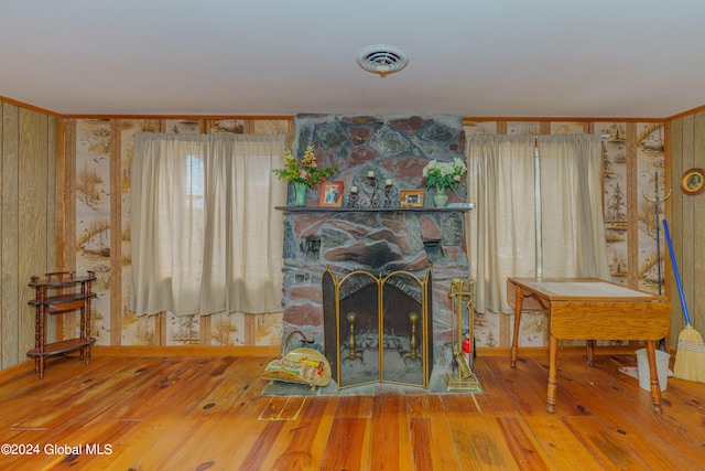 living room with a stone fireplace and hardwood / wood-style flooring