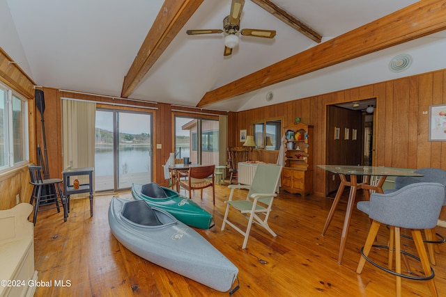 living room with vaulted ceiling with beams, ceiling fan, light hardwood / wood-style floors, and radiator heating unit