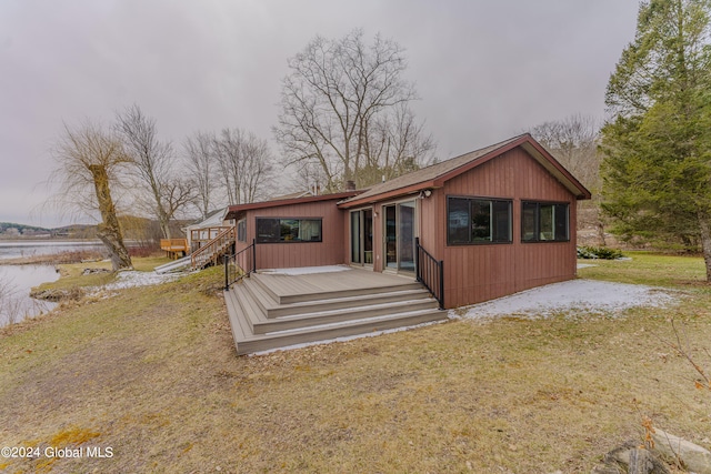 view of front of house featuring a front lawn and a deck with water view