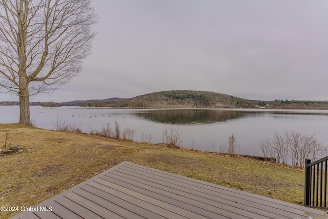 wooden terrace featuring a lawn and a water view