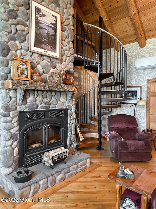 living room featuring a wall mounted AC, wooden ceiling, a stone fireplace, vaulted ceiling with beams, and hardwood / wood-style flooring