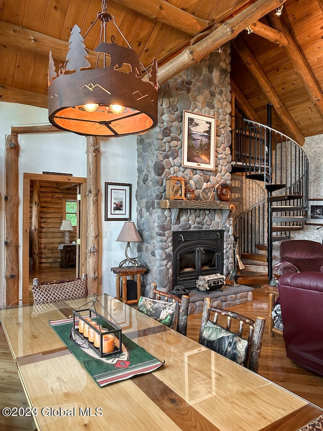 living room featuring log walls, a stone fireplace, and beam ceiling