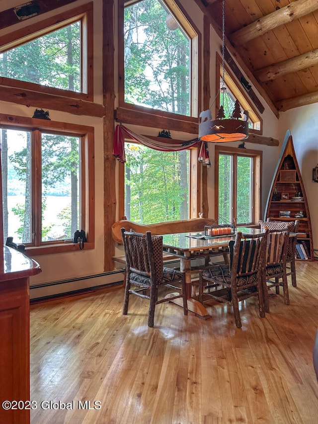 dining space featuring beamed ceiling, high vaulted ceiling, light hardwood / wood-style floors, a baseboard heating unit, and wood ceiling