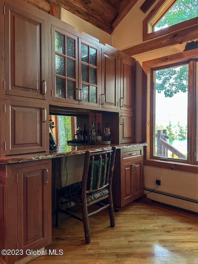 office space featuring a baseboard heating unit, lofted ceiling, and light hardwood / wood-style floors