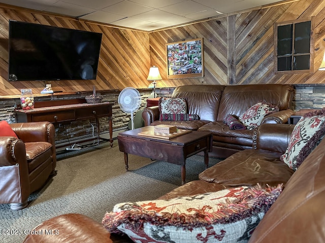 carpeted living room featuring wooden walls