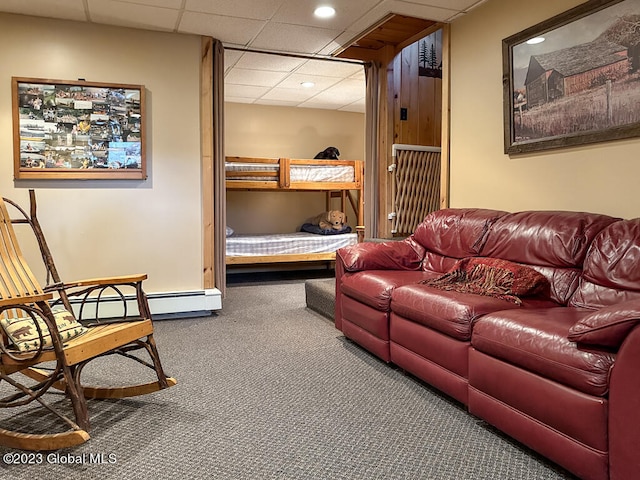 interior space featuring baseboard heating, dark colored carpet, and a paneled ceiling