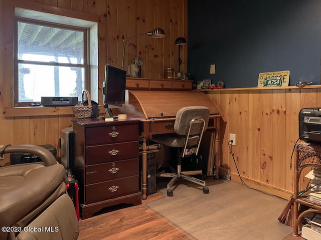 office space with wood walls and light wood-type flooring