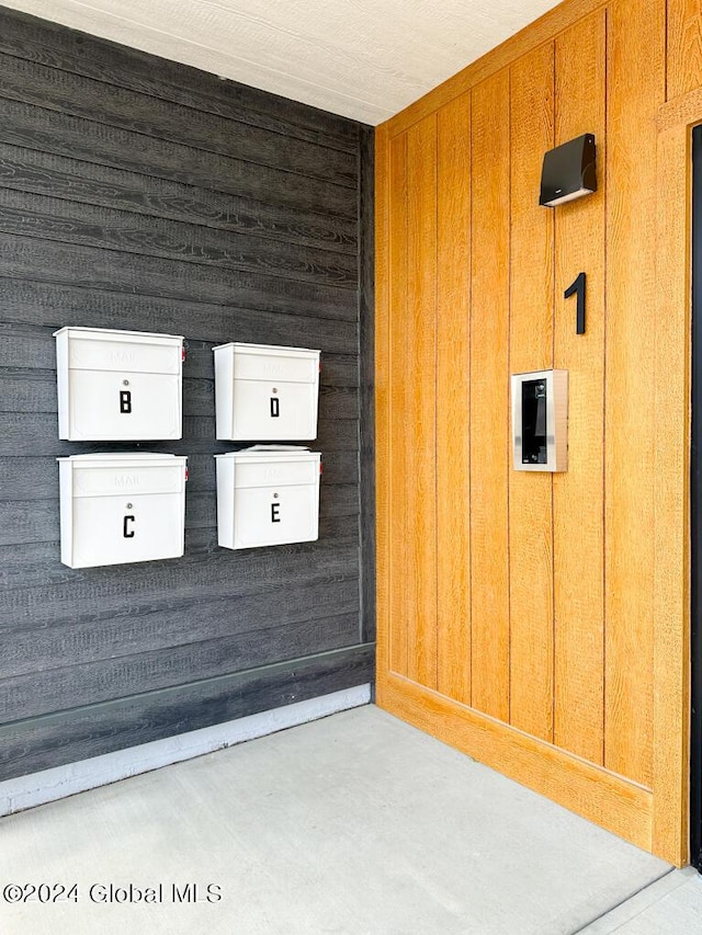 interior space with concrete flooring and wooden walls