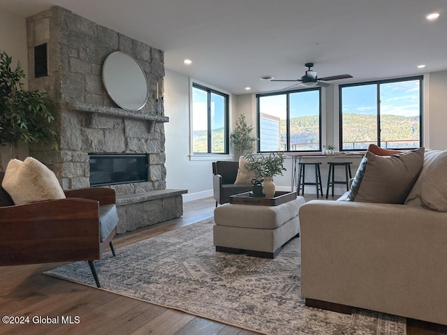 living room featuring a fireplace, hardwood / wood-style floors, and ceiling fan