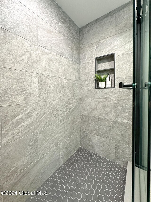 bathroom featuring a tile shower and tile patterned flooring