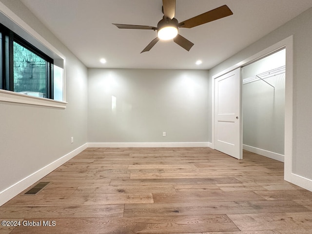 unfurnished bedroom featuring ceiling fan, light wood-type flooring, and a closet