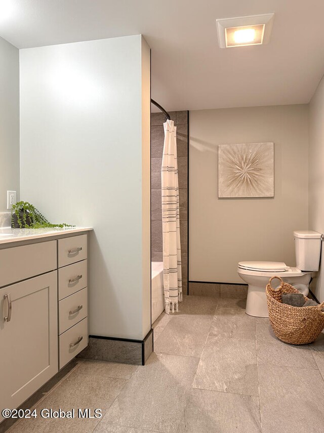 full bathroom featuring shower / tub combo with curtain, vanity, and toilet