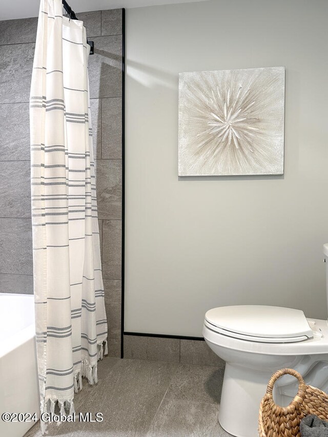 bathroom featuring shower / tub combo and toilet