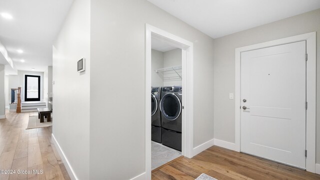 laundry room with separate washer and dryer and light hardwood / wood-style flooring