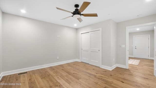 unfurnished bedroom with ceiling fan, light hardwood / wood-style floors, and a closet