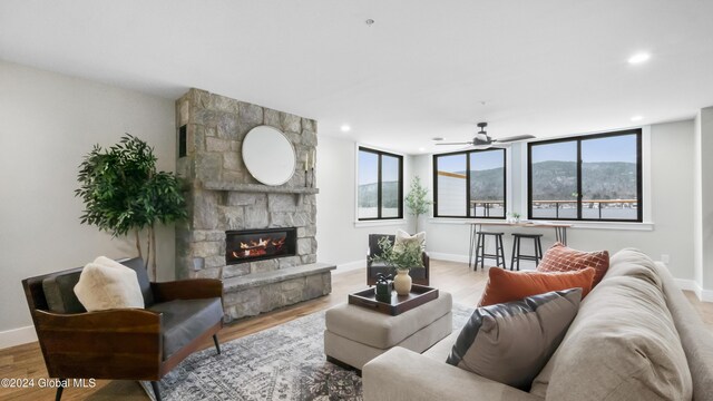 living room with a fireplace, hardwood / wood-style flooring, and ceiling fan